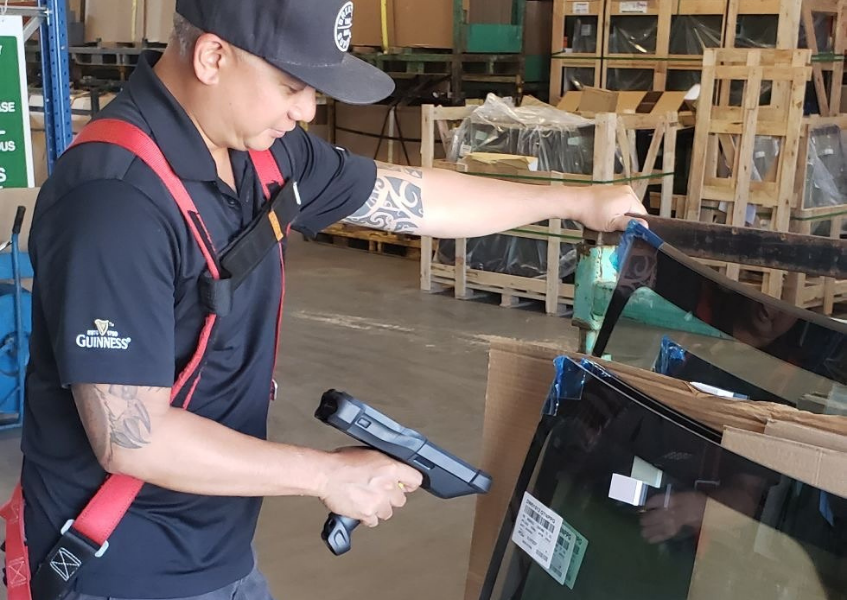 Man scanning PGW Auto Glass windshield with a scanner gun.